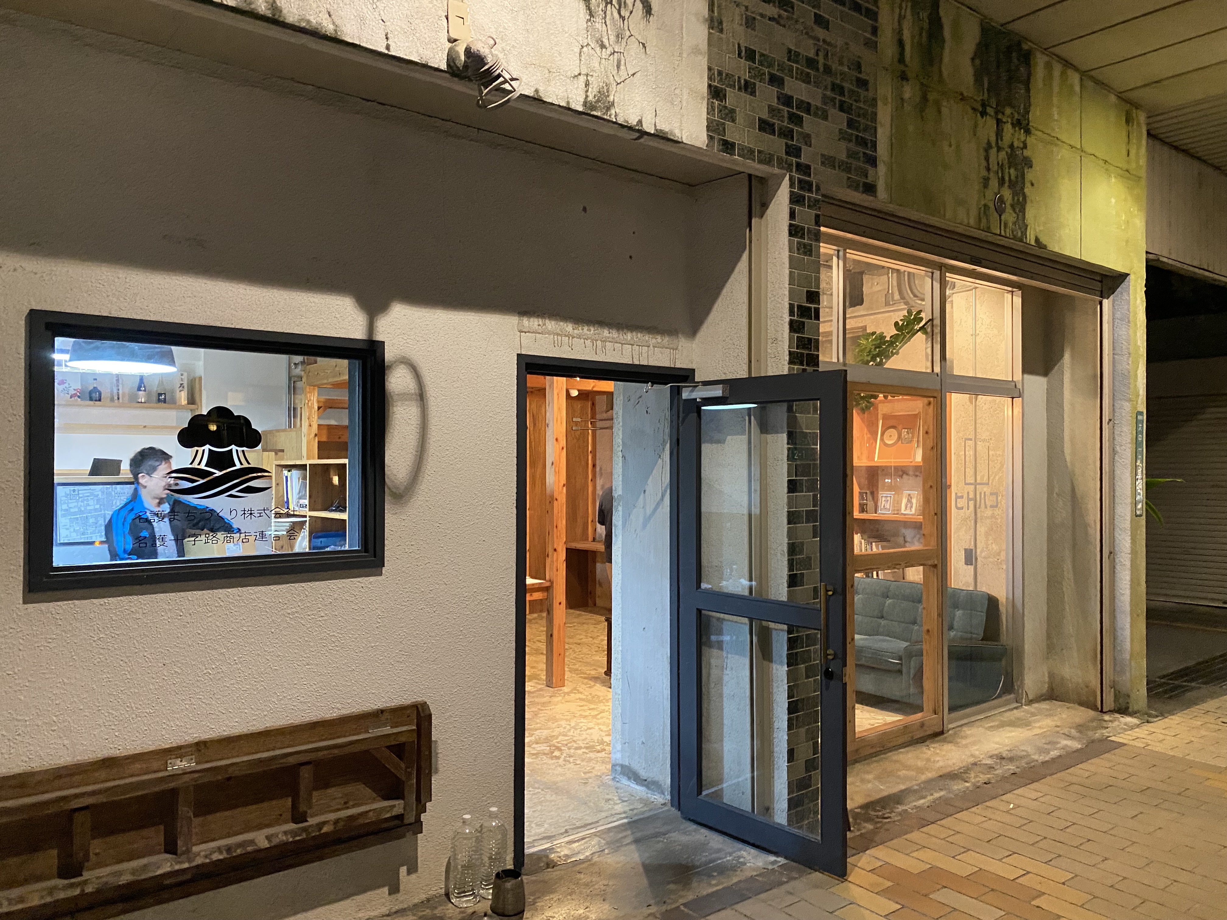 ヒトハコの店舗外観。夜間、暖かい光がガラス越しに漏れる店構え。